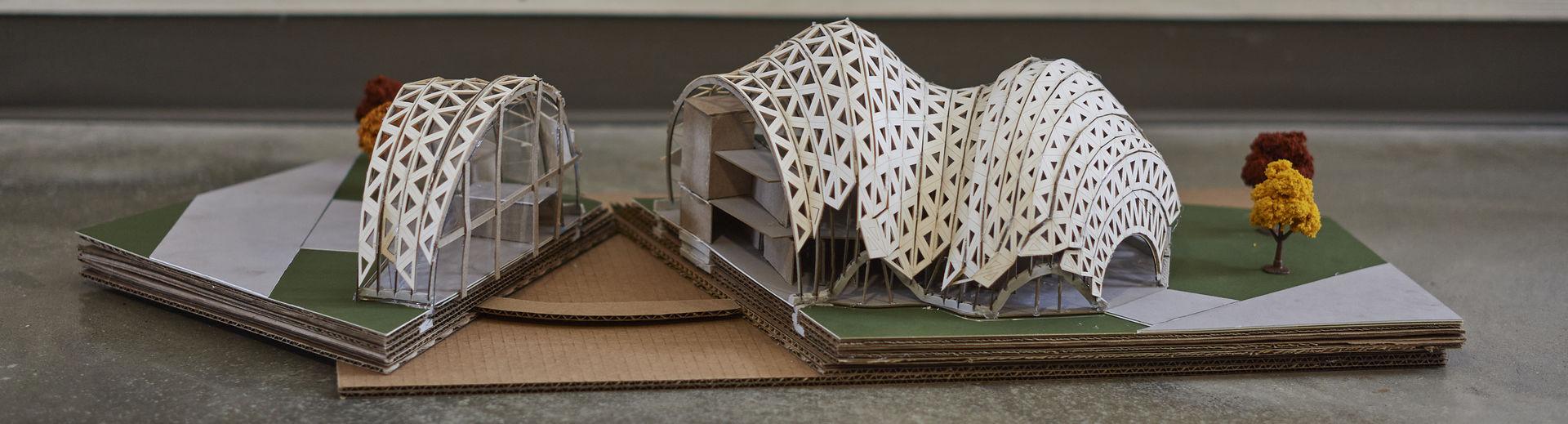An architectural model of a structure with a curved roof is shown.